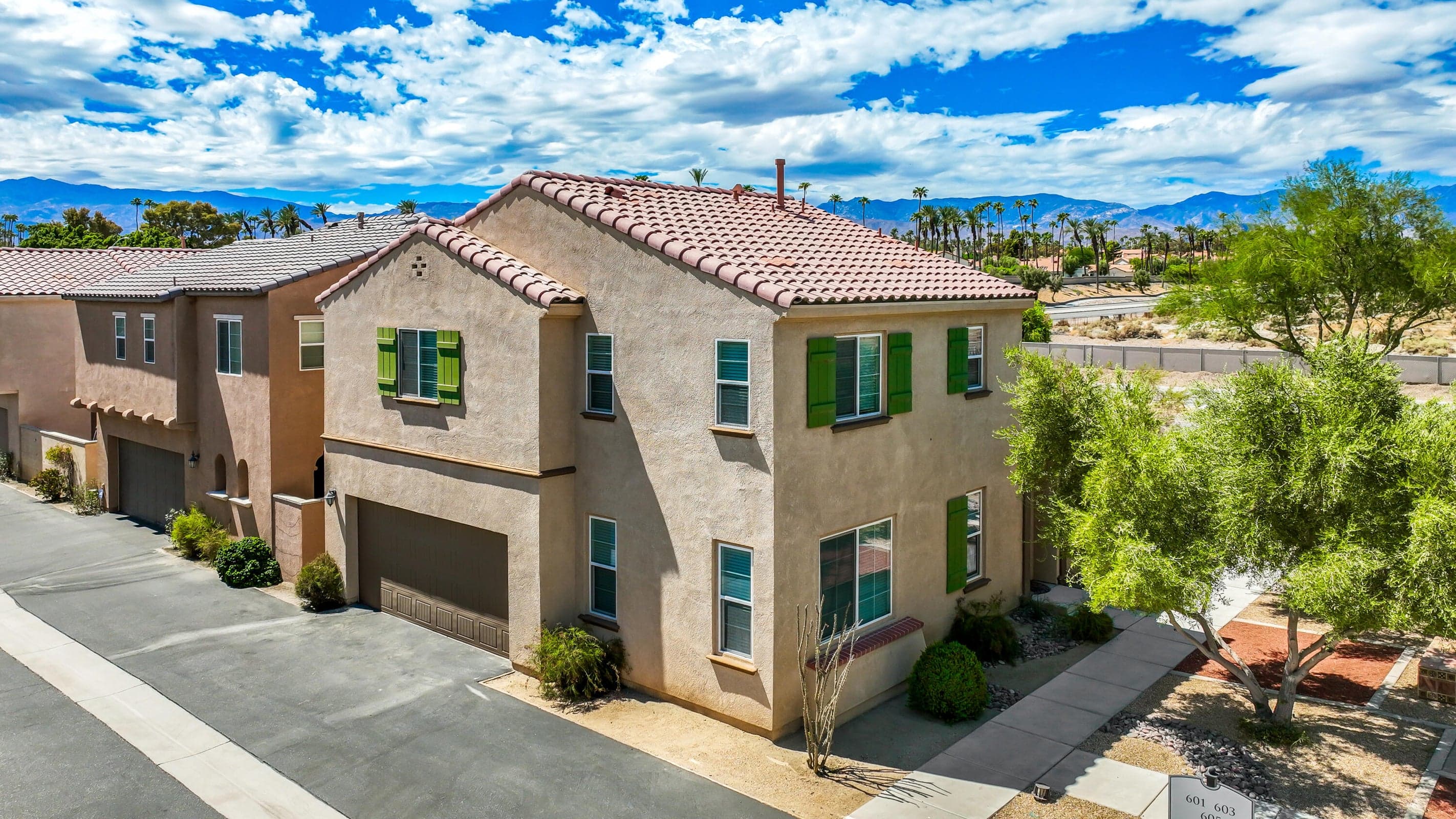 Overview of home with 2-car garage on left and front door on right.