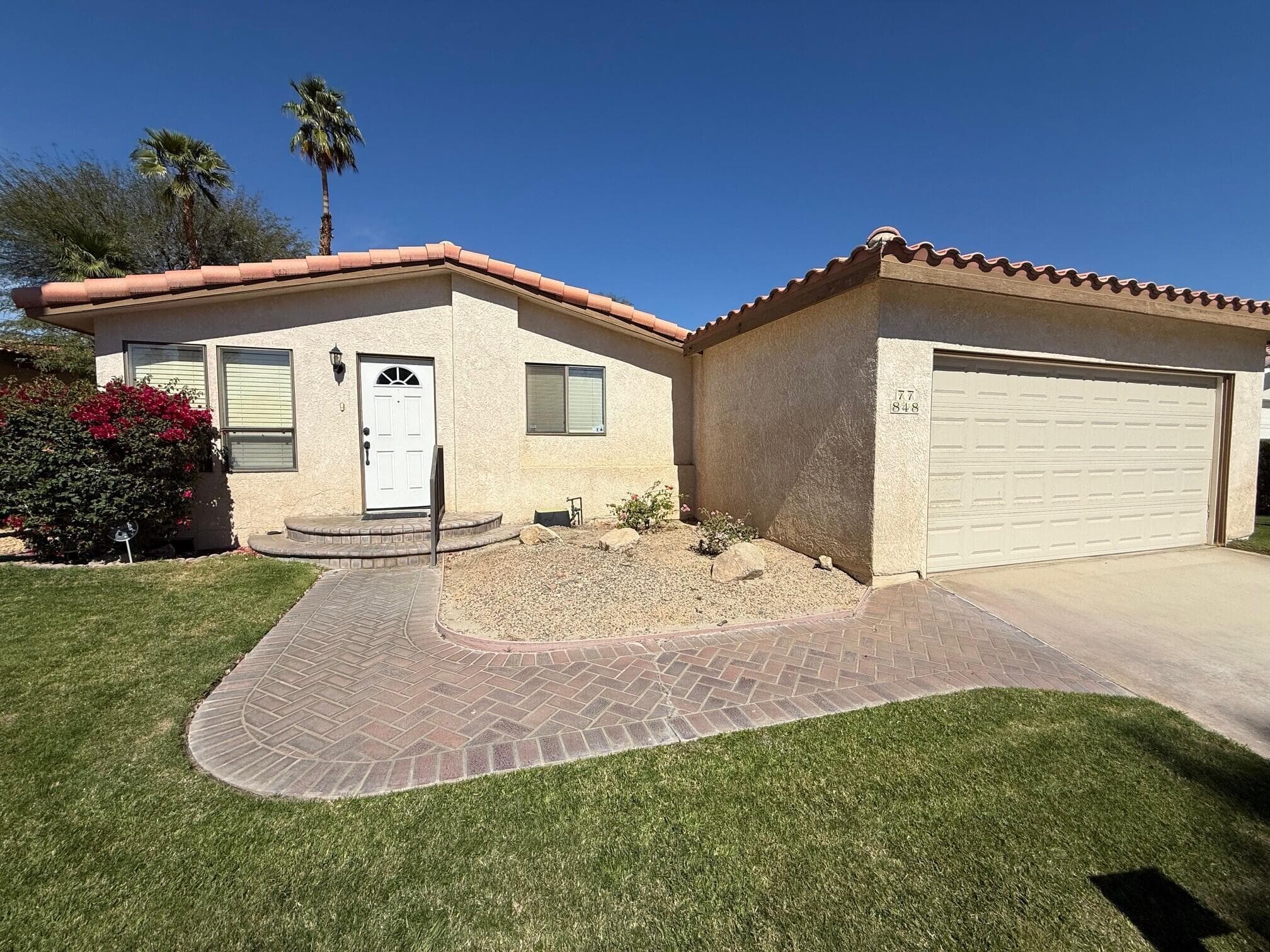 Front of home with tile roof and attached 2 car garage