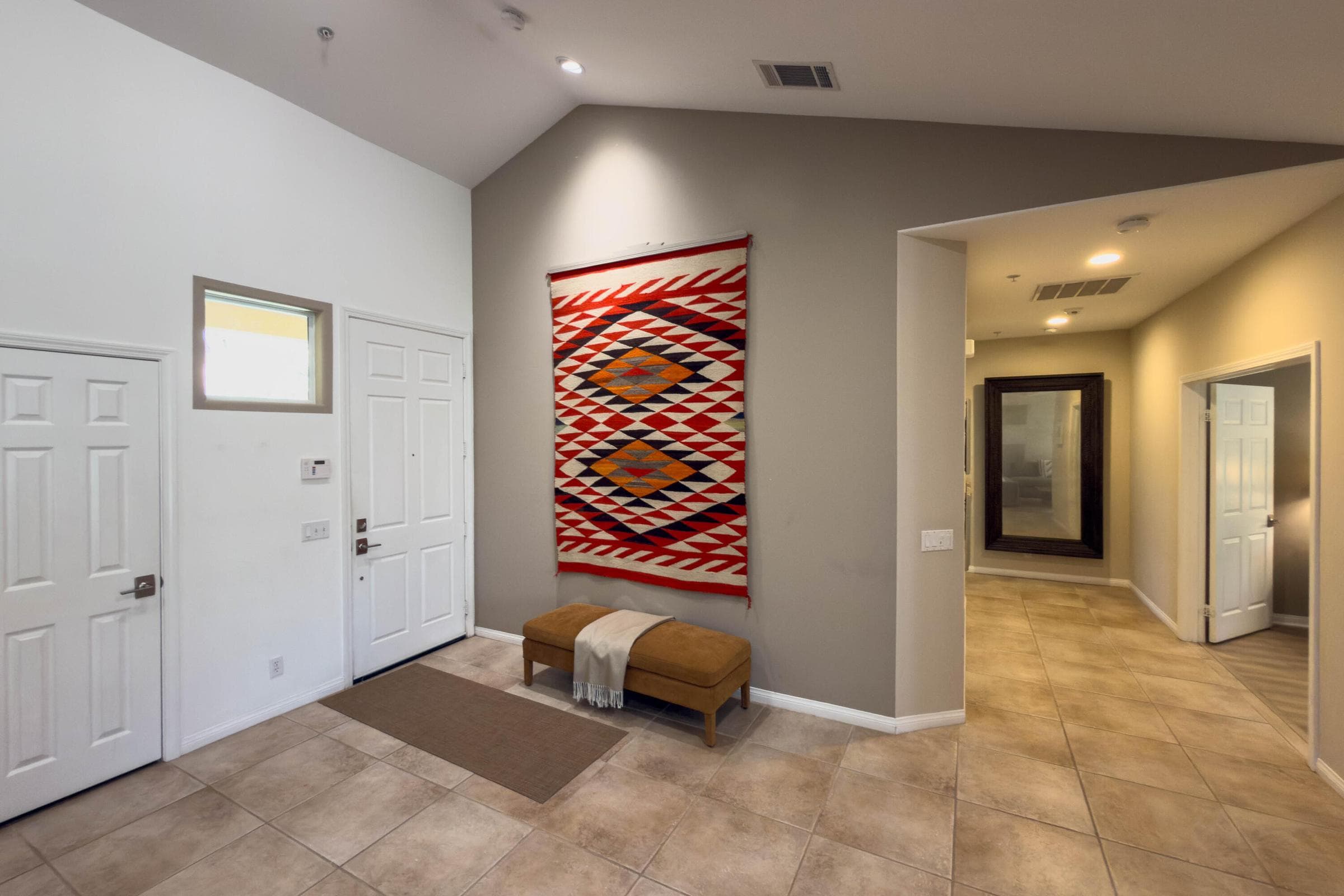 Front entry / foyer to great room and hallway to primary bedroom and guest bedroom 2/office.
