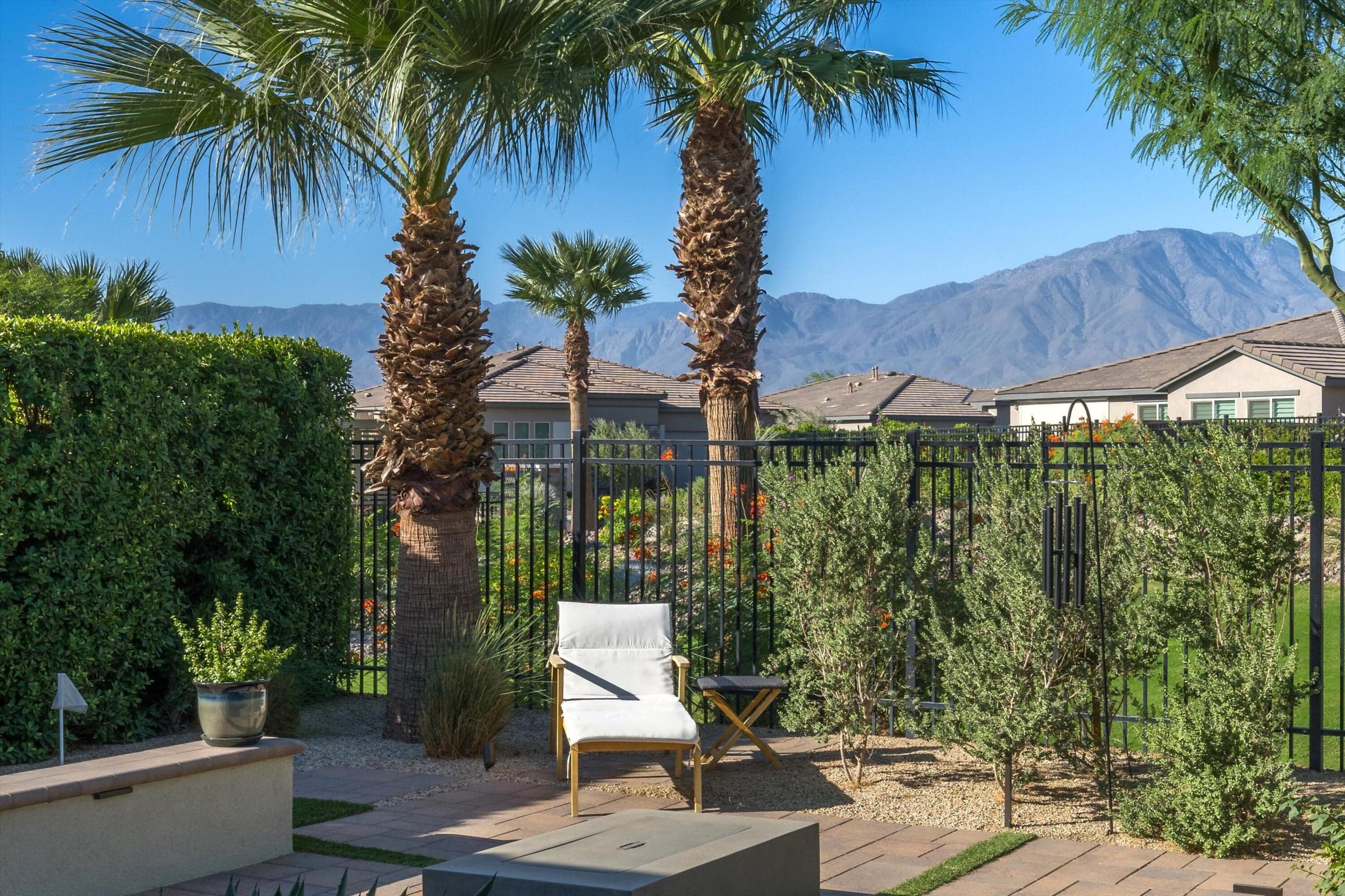 notice the privacy hedges on both sides of the property and inlaid artificial grass amongst the pavers!